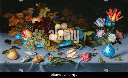 Stillleben mit Früchten und Blumen. Auf einer weißen Tischdecke etwas Obst auf einem Porzellangeschirr und ein Blumenstrauß in einer Porzellanvase. Darüber hinaus Shell Stockfoto