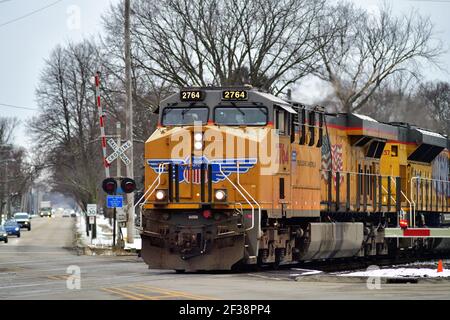 West Chicago, Illinois, USA. Ein Güterzug der Union Pacific Railroad, der durch eine Straßenkreuzung fährt. Stockfoto