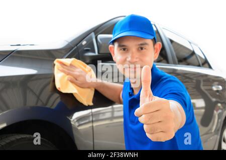 Ein Mann, der Daumen nach oben während der Reinigung Auto, Auto Detaillierung (oder Valeting) Konzept Stockfoto