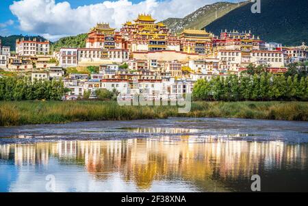 Songzanlin Kloster mit wunderschönen Wasserspiegelungen am See in Shangri-La Yunnan China Stockfoto