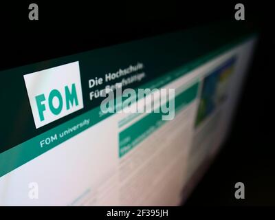 Hochwinkelansicht der Website mit Logo der FOM Hochschule für Wirtschaft und Management auf Monitor. Konzentrieren Sie sich oben links auf dem Bildschirm. Stockfoto