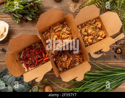 Chinesisches Restaurant Take-out Box mit verschiedenen Speisen auf Holzhintergrund, Blick von oben Stockfoto