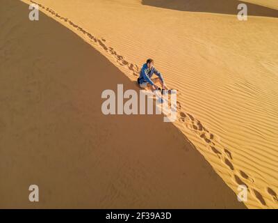 Mann, der in der Wüste reist. Sanddünen und blauer Himmel an sonnigen Sommertagen. Reise, Abenteuer, Freiheit Konzept. Tourismus wieder eröffnet nach Quarantäne COVID Stockfoto