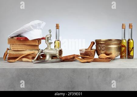 Kochmütze, alte Kochbücher und alte Küchenutensilien auf dem Küchentisch. Speicherplatz kopieren. Stockfoto