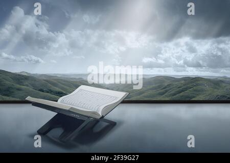 Quran offen in Holzplacemat mit Blick auf die Berge im Hintergrund Stockfoto