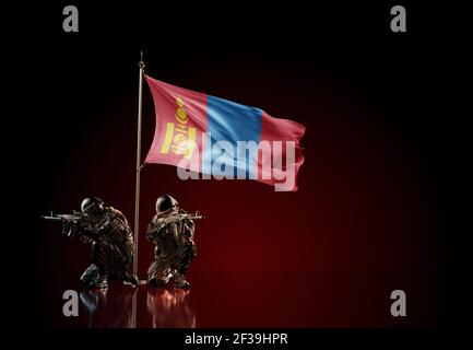 Konzept des militärischen Konflikts mit Soldaten Statuen und winkende Nationalflagge der Mongolei. Illustration der Coup-Idee. Zwei Wachen verteidigen das Symbol Stockfoto