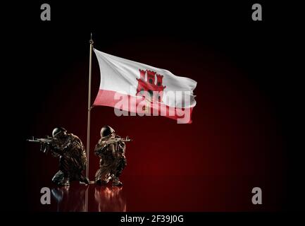 Konzept des militärischen Konflikts mit Soldatenstatuen und wehender Nationalflagge von Gibraltar. Illustration der Coup-Idee. Zwei Wachen verteidigen das Symbol Stockfoto