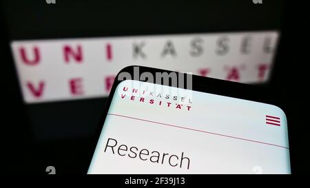 Handy mit Website der deutschen Bildungseinrichtung Universität Kassel auf dem Bildschirm vor dem Logo. Konzentrieren Sie sich auf die obere linke Seite des Telefondisplays. Stockfoto