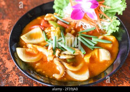 Gebratener Tintenfisch mit gesalzenem Eigelb auf weißem Teller auf Tischhintergrund, Curry-Tintenfisch umrühren Stockfoto