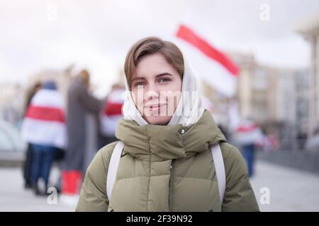 Weißrussische Frau stehende Gruppe von Demonstranten mit belarussischen Fahnen an Hintergrund des friedlichen Protestes gegen illegale Präsidentschaftswahlen in Belaru Stockfoto