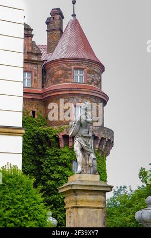 Walbrzych, Polen - Juni 2015: Außenansicht des Schlosses Książ mit geschnitzter Statue des Minnesänges, die Laute spielt, und kreisförmigem Turm im Hintergrund Stockfoto