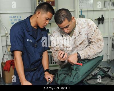 Flight Equipment Technician Cpl. Michael Martinez und Aircrew Survival Equipmentman Airmen Nilo Paulo testen die PSI von Rettungsschützen an Bord des amphibischen Sturmschiffs USS Makin Island (LHD 8). Makin Island und eingeschiffte Marineinfanteristen, die der Marine Expeditionary Unit 11th zugewiesen sind, werden im Einsatzgebiet der US-7th-Flotte eingesetzt. (USA Navy Foto von Mass Communication Specialist Seaman Lehrling Daniel J. Walls/Freigegeben) Stockfoto