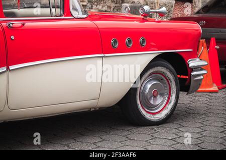 Santo Domingo, Dominikanische Republik - 11. Januar 2020: Rotweißer Oldtimer. Oldtimer-Fragment. Tür, Rad und Flügel der Buick Special Limousine 1955, Stockfoto