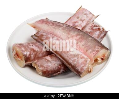 Auf einem Teller liegende Stücke gefrorener schwarzer Congrio-Fische Isoliert auf Weiß Stockfoto