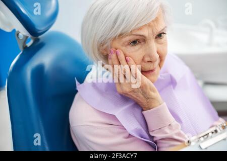 Besorgtes Rentner mit Zahnschmerzen starren auf Zahnarzt Stockfoto