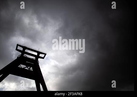 Herne Wanne, Deutschland. März 2021, 16th. Dunkle Wolken ziehen über den verwinkelten Turm der ehemaligen Pluto-Kolonie. In den kommenden Tagen wird das Wetter in Nordrhein-Westfalen wechselhaft sein. Aber dichte Wolken ziehen hinein. Regen fällt an Orten, Schnee in den Bergen. Quelle: Federico Gambarini/dpa/Alamy Live News Stockfoto