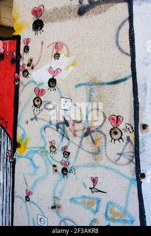 Graffiti um die Einschusslöcher in der Wand des Scharfschützenturms, einer ehemaligen Bank, die während des Bosnienkrieges als Scharfschützenansichtspunkt genutzt wurde.Mostar, Bosnien und Herzegowina. Stockfoto