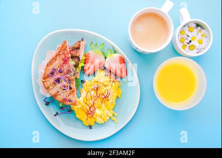 Grobes Brot Toast mit Schinken, Salat und Scramble, bestreut mit gekeimtem Samen. Super Essen. Leckeres gesundes Frühstück auf einem hellen Hintergrund. Hochwertige Fotos. Draufsicht Stockfoto