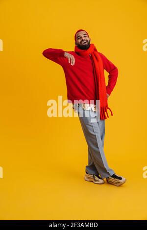 Porträt von entspannten jungen afrikanischen Mann lehnt an einer gelben Wand Hintergrund, voller Länge Stockfoto