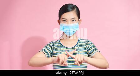 Portrait Asian schöne glückliche junge Frau trägt Gesichtsmaske schützt Filter Staub PM2,5 Anti-Verschmutzung, Anti-Smog und Luftverschmutzung ihre Finger zeigen Stockfoto