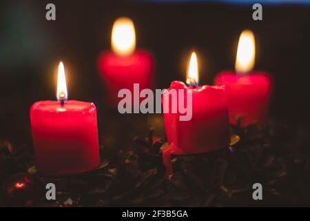 Dezem Studiofoto eines schönen Adventskranzes mit Kugeln Und eine brennende rote Kerze Stockfoto