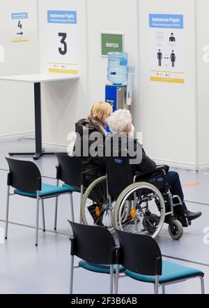 Perleberg, Deutschland. März 2021, 16th. Eine ältere Dame mit Begleitung wartet im neu eröffneten Impfzentrum Prignitz in der Rolandhalle. Der Standort Perleberg ist das zwölfte Impfzentrum im Land Brandenburg. Quelle: Soeren Stache/dpa-Zentralbild/ZB/dpa/Alamy Live News Stockfoto