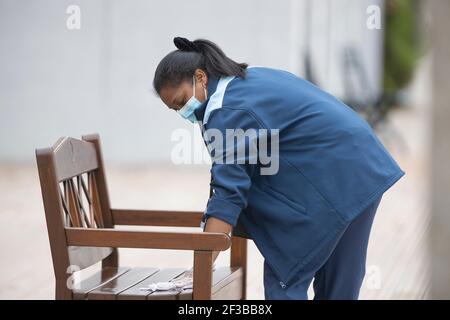 Putzfrau mit OP-Maske Wischbank mit antiseptischer Lotion bei den French Open 2020, Paris, Frankreich, Europa Stockfoto