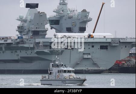 Das Royal Navy Bogenschützenschiff HMS Smiter passiert den Flugzeugträger HMS Prince of Wales bei HMNB Portsmouth. Bilddatum: Dienstag, 16. März 2021. Stockfoto