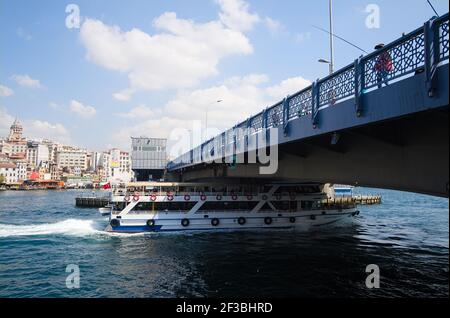Istanbul, Türkei - September, 2018: Passagierfähre unter der Galata-Brücke in Bosporus. Fischer fischen auf der Brücke über die Gold Horn Bucht. Stockfoto