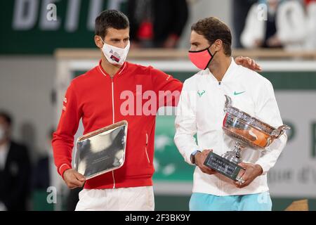 Der zweite Novak Djokovic (SRB) gratuliert Rafael Nadal, der die Trophäe nach dem Gewinn seiner 13th. meisterschaften während der Präsentation bei den French Open hält Stockfoto