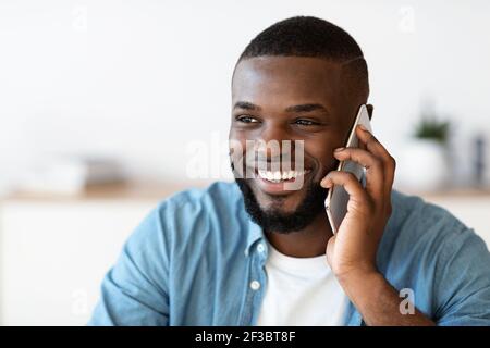 Angenehmer Anruf. Positive Millennial Black Man Im Gespräch Auf Handy Und Lächeln Stockfoto