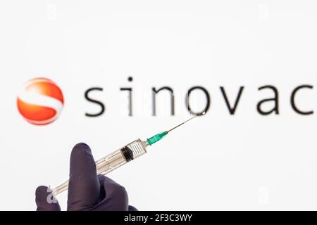 CLUJ-NAPOCA -RUMÄNIEN - MÄRZ 9 2021: Sinovac Impfstoff Covid-19 Konzept. Spritzennadel und Impfstoff, verschwommen Sinovac Firmenlogo auf dem Hintergrund. Stockfoto