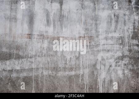 Betonwand mit weiß tropfender Farbe, grunge Hintergrund oder Textur Stockfoto