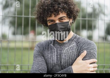 Ein hübscher, athletischer spanischer Mann posiert in einem schwarzen Einwegartikel Schutzmaske Stockfoto