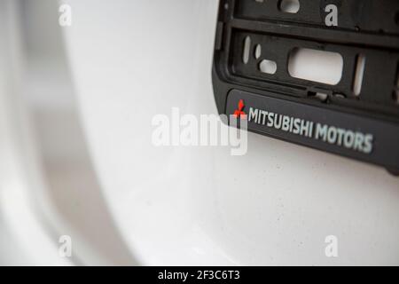Moskau, Russland: - 30. September 2019: Mitsubishi Motors Logo auf Nummernschildrahmen auf weißem Auto Nahaufnahme, selektiver Fokus. Stockfoto