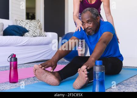 Diverse ältere Paar trainieren sitzen auf Yoga-Matten Stretching Stockfoto