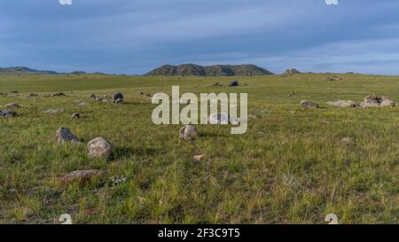 Camper und Camping an Steinformationen in der Nähe von Orkhon und Jargalant in der Mongolei in der Steppe bei Sonnenuntergang am Abend. Stockfoto