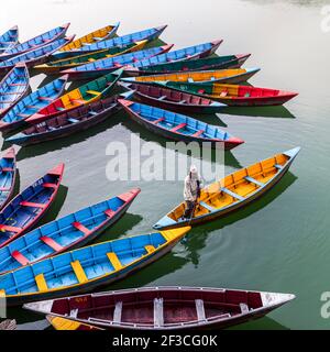 Pokhara, Nepal - 21. November 2015: Mann rudert im Boot auf dem Phewa See in Pokhara. Stockfoto