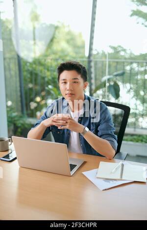 Jungen gutaussehenden Mann arbeitet zu Hause mit seinem Laptop Stockfoto