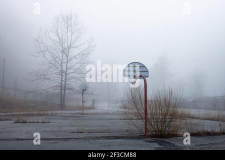 Verlassene Basketball Ziele stehen in dicken Morgennebel. Stockfoto