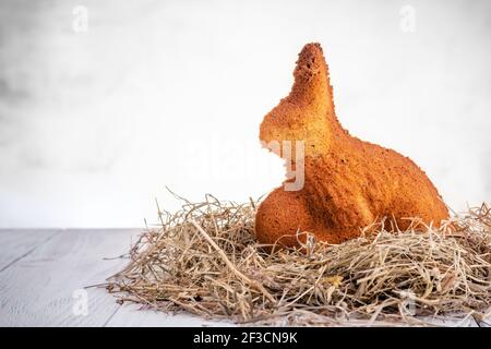 Gebackener osterhase auf Stroh auf Holzhintergrund Stockfoto