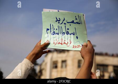 15. März 2021: Idlib, Syrien. 15. März 2021. Am zehnten Jahrestag des Ausbruchs der syrischen Revolution findet in der von der Opposition gehaltenen syrischen Stadt Idlib eine große Demonstration statt. Beamte der syrischen Heilsregierung der Opposition und Mitglieder der Zivilverteidigung waren unter den Syrern, die in Idlib auf die Straße gingen, um 10 Jahre seit der ersten Demonstration gegen die Herrschaft von Präsident Baschar Assad zu markieren. Einige Demonstranten trugen die drei-Sterne-Flagge der Opposition und Bilder der während des Konflikts Getöteten. Der Volksaufstand im März 2011 in Syrien hat sich allmählich rasend angespießt Stockfoto