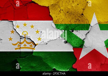 Flaggen von Tadschikistan und Myanmar auf rissige Wand gemalt Stockfoto