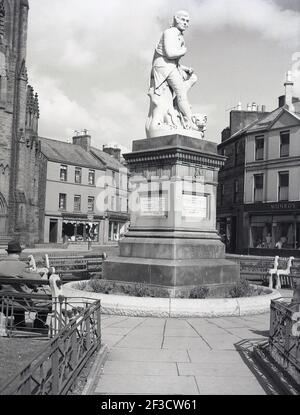 1961, historisch, eine Statue zu Ehren des schottischen Schriftstellers und Nationaldichters Robert Burns, auf dem Platz der Marktstadt Dumries, Schottland, wo er von 1791 bis 1796 lebte. Entworfen von Amelia Robertson Hill, wurde die Statue 1882 in Carrara, Italien, geformt und ihre Lage in Dumfies bedeutet, dass sie von der Grayfairs Kirche übersehen wird. Stockfoto