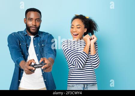 KIEW, UKRAINE - 23. OKTOBER 2020: afroamerikanerin, die auf Blau den Mann beim Spielen anschaut Stockfoto