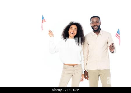 Fröhliches afroamerikanisches Paar lächelt an der Kamera, während es klein hält Flaggen der usa isoliert auf weiß Stockfoto