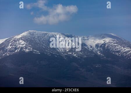 Foto von Moncayo, dem höchsten Berg des Iberischen Systems, bedeckt mit Schnee an seiner Spitze, an einem sonnigen Wintertag. Auf seinen Hängen, dunkle Wälder von Stockfoto