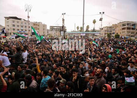 15. März 2021: Idlib, Syrien. 15. März 2021. Am zehnten Jahrestag des Ausbruchs der syrischen Revolution findet in der von der Opposition gehaltenen syrischen Stadt Idlib eine große Demonstration statt. Beamte der oppositionâ €™s Syrische Heilsregierung und Mitglieder der Zivilverteidigung waren unter den Syrern, die auf die Straße in Idlib zu markieren 10 Jahre seit der ersten Demonstration gegen Präsident Bashar Assadâ €™s Regel. Einige Demonstranten trugen die drei-Sterne-Flagge der Opposition und Bilder der während des Konflikts Getöteten. Der Volksaufstand im März 2011 in Syrien hat sich allmählich rasend angespießt Stockfoto