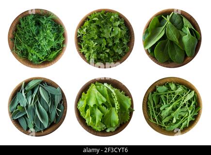 Draufsicht. Frischer grüner Salat und Kräuter isoliert auf weißem Hintergrund. Salbeiblätter, Salat, Rucola, Spinat, Petersilie und Dill in Holzschüssel. Ve Stockfoto