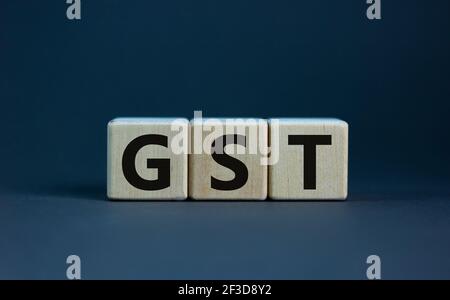 GST, Steuersymbol für Waren und Dienstleistungen. Konzept Worte GST, Waren und Dienstleistungen Steuer auf Holzwürfel auf einem schönen grauen Hintergrund. Business und GST, Waren Stockfoto